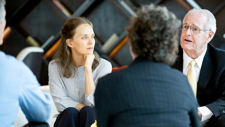 Four adults of various ages sitting in discussion