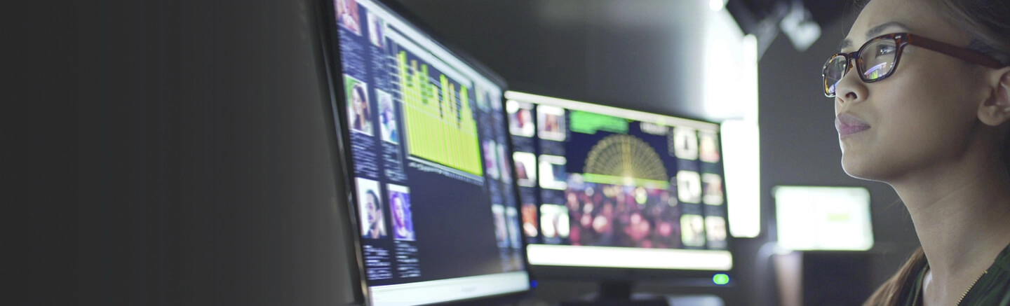 Woman working with 2 computer monitors