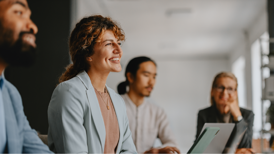 A group of people smile inside an office.