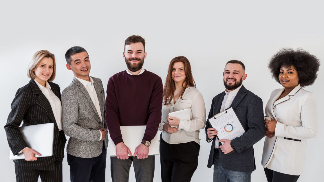 A group of people in formal work clothes stand holding laptops and folders and a clipboard with some data printed on it on a white background.