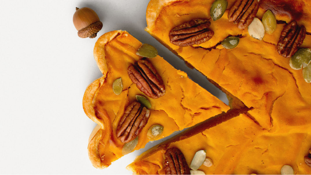 The perfect recipe for a successful hiring process: A close-up image of a pie with different nuts in a white background. There is an acorn beside it.