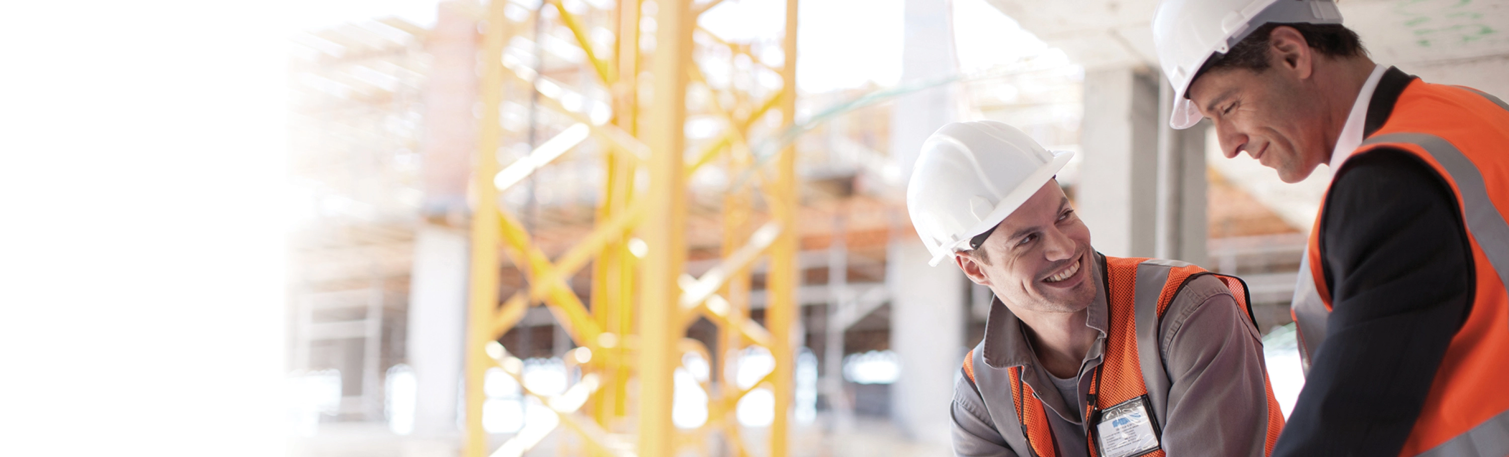 Two senior construction workers looking at plans on a high-rise site