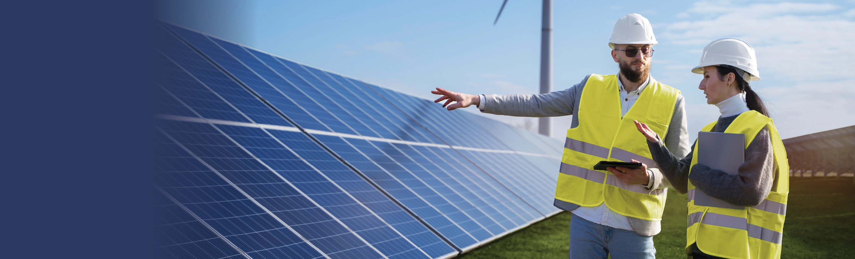 Man and woman with safety vests inspecting solar panels